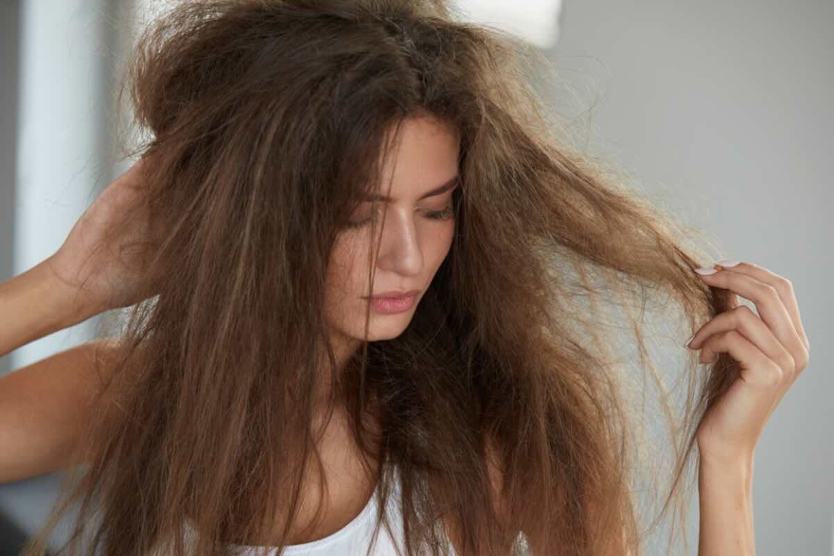 donna che guarda e tocca capelli crespi